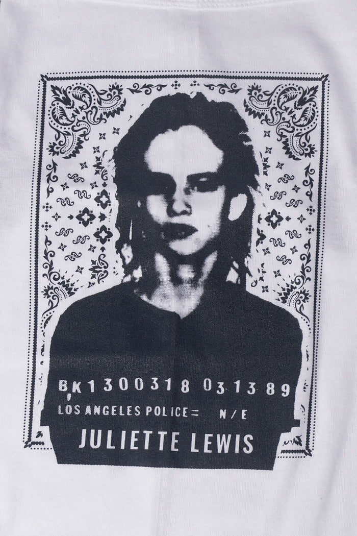 Close up of graphic design on white dog tee laying on a gray surface