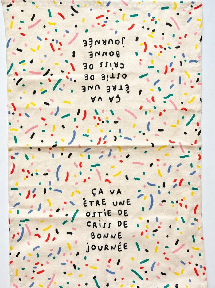 Linge à vaisselle motif confeti avec les couleurs primaires inscrit: ça va être une ostie de criss de bonne journée. Parfait idée cadeau pour femme. Fait au Québec.