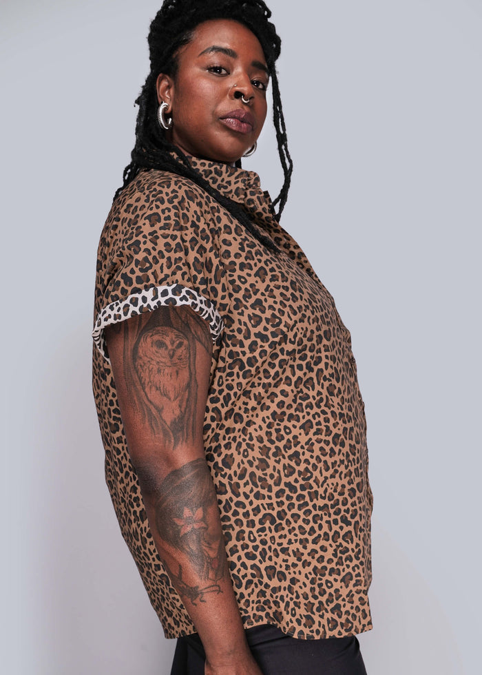 1X=Person wearing a leopard print shirt on a plain background