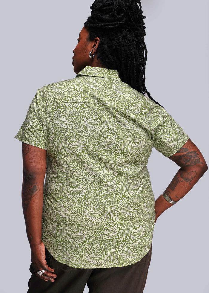 1X=Person wearing a green patterned shirt against a plain background