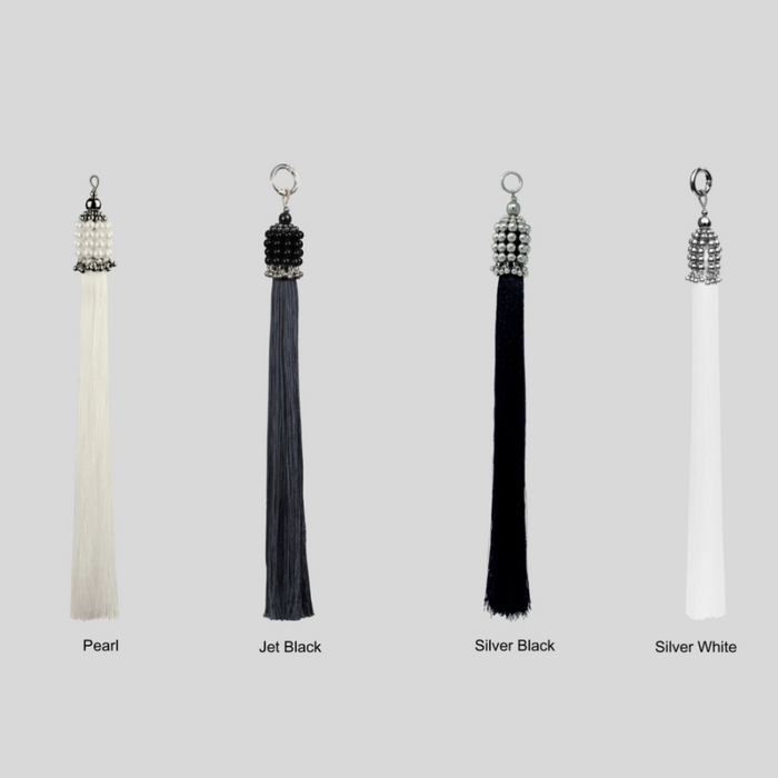 Set of four tassels in different colors with siver, pearl, and black crsytal beads on a grey background by Object&Dawn