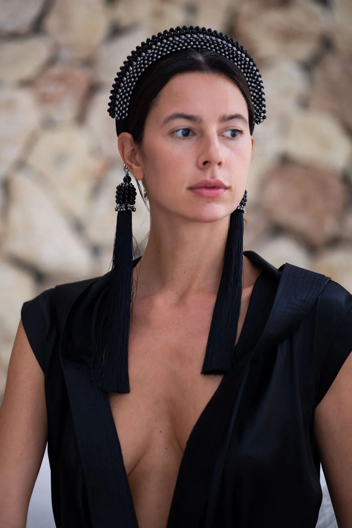 Beaded handcrafted polyester tassel by silver coated metal beads with black crystals with modular headband on grey background