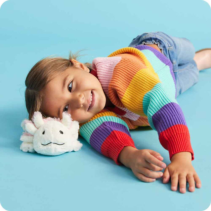Little girl laying down and smiling at Cute Weighted Lavender Scented Axolotl Stuffed Animal Heating Pad Warmies Junior