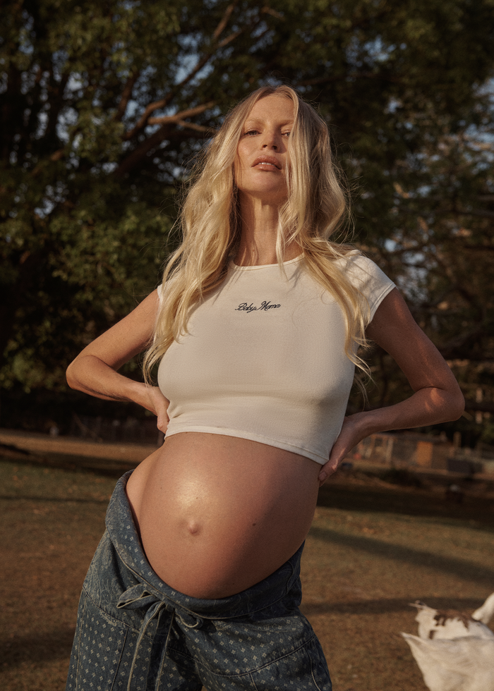 pregnant woman wearing a Bumpsuit baby mama tee and pants outdoors