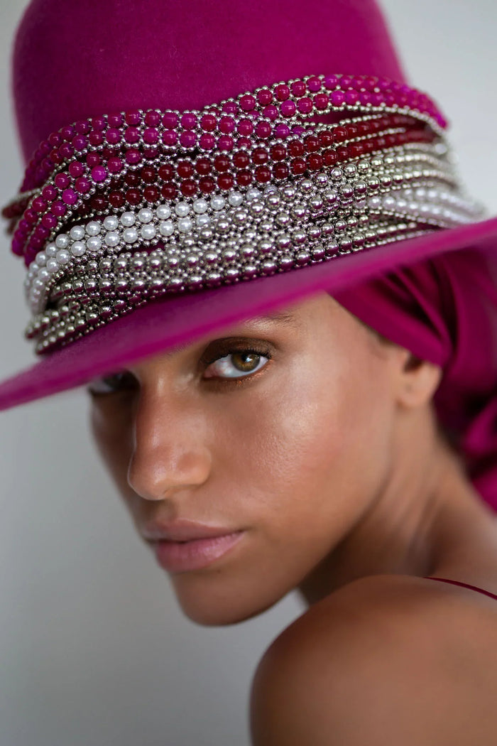 close up of mix hat band accecories pink red pearl silver on pink hat worn view in grey background by object and dawn