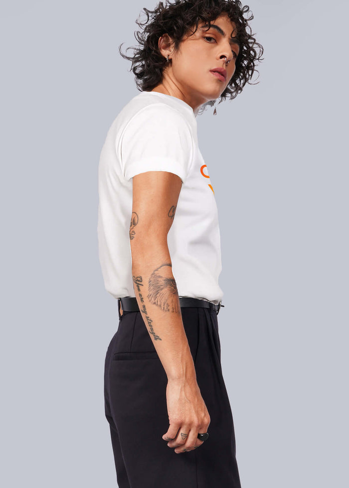 S=Person wearing a white t-shirt, black skirt, and black shoes against a plain background