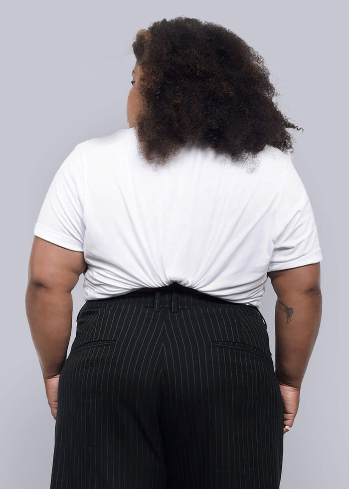 1X=Person wearing a white t-shirt and black wide-leg pants against a plain background