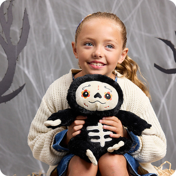 girl holding day of the dead sloth stuffed animal