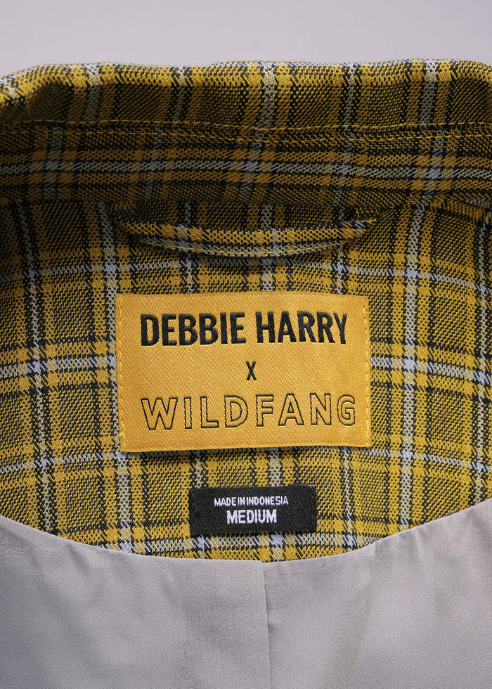 Plaid fabric with a label reading 'Debbie Harry x Wildfang' on a gray background
