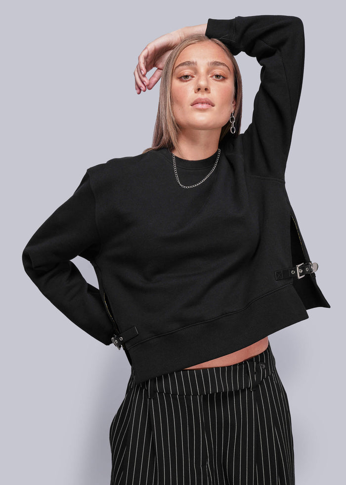 S=Person wearing a black sweatshirt with a plain background