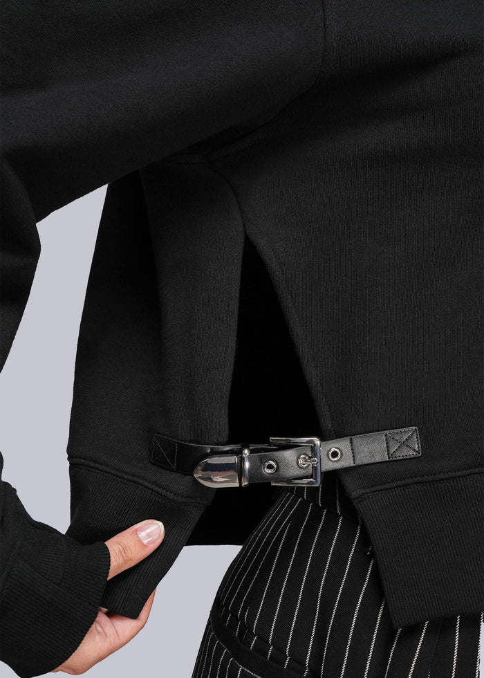 S=Close-up of a sweatshirt with buckle and pinstripe pants on a light gray background