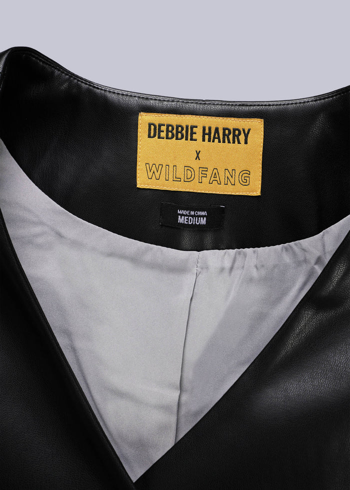 Close-up of a black leather vest with a label reading 'Debbie Harry x Wildfang'.
