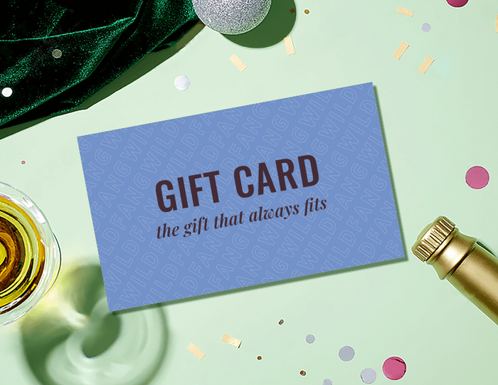 A gift card sits on green backdrop with champagne glass, and bottle of champagne.