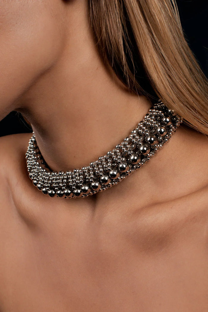 woman in black dress with beaded modularhelios optical 3d choker in silver by object & dawn