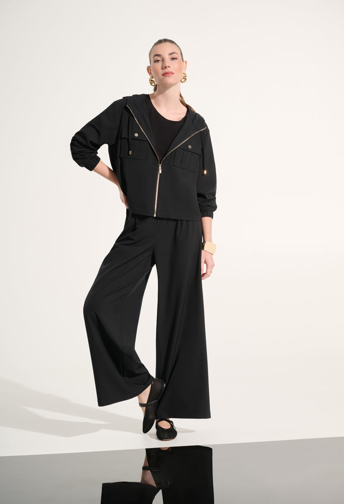 Person wearing a black outfit with wide-leg pants on a white background