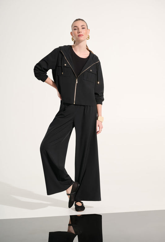 Person wearing a black outfit with wide-leg pants on a white background