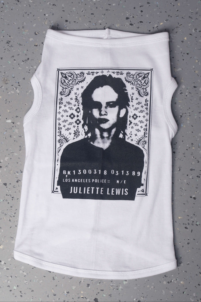 White dog shirt with graphic design laying flat on a gray surface