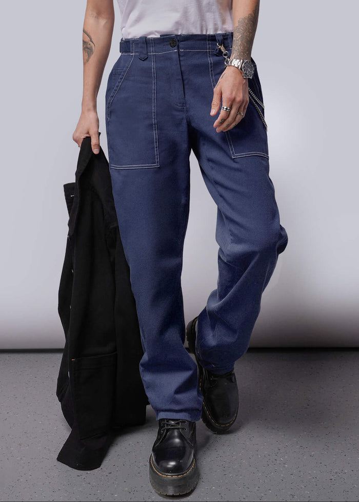 S=Person wearing a white sleeveless shirt and blue pants holding a black jacket against a plain background