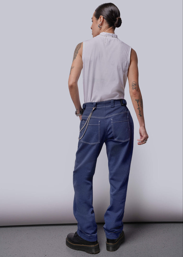S=Person wearing a sleeveless shirt and blue pants against a plain background