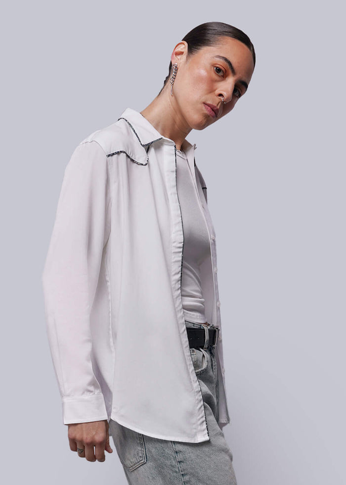 S=Person wearing a light-colored shirt and jeans against a plain background