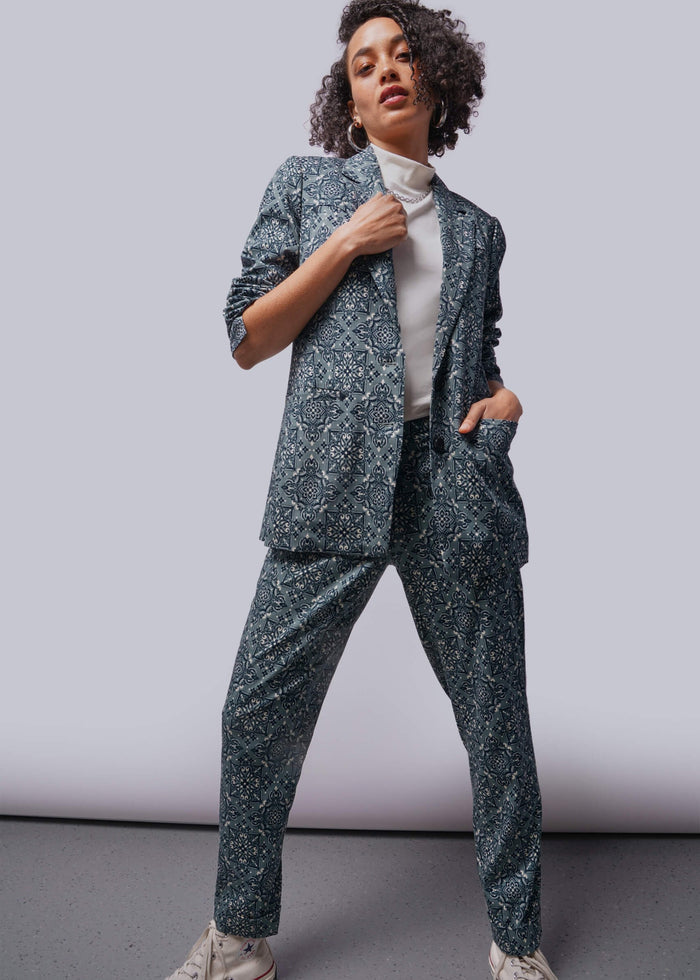 S=Person wearing a patterned suit with a plain background