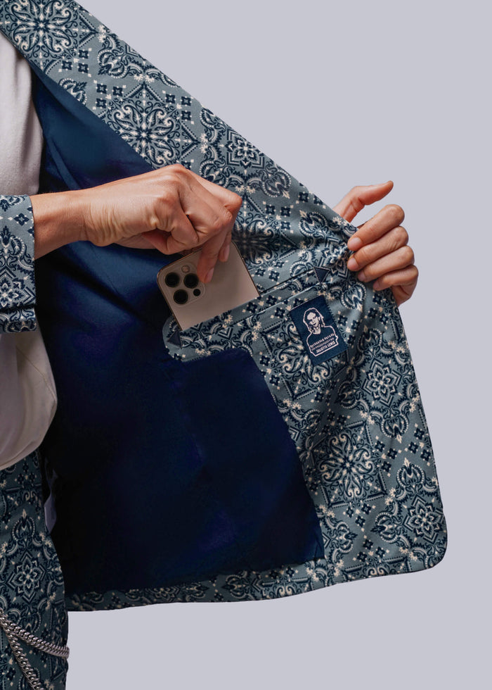S=Person putting a phone in interior blazer pocket on grey background