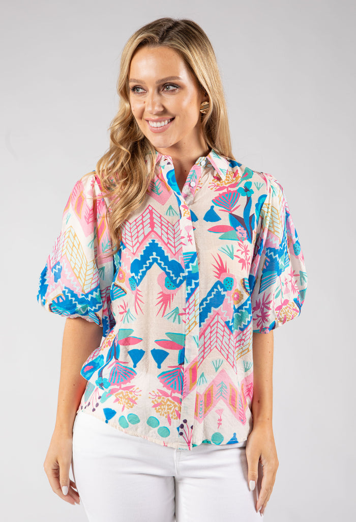 Woman wearing a colorful patterned blouse on a white background