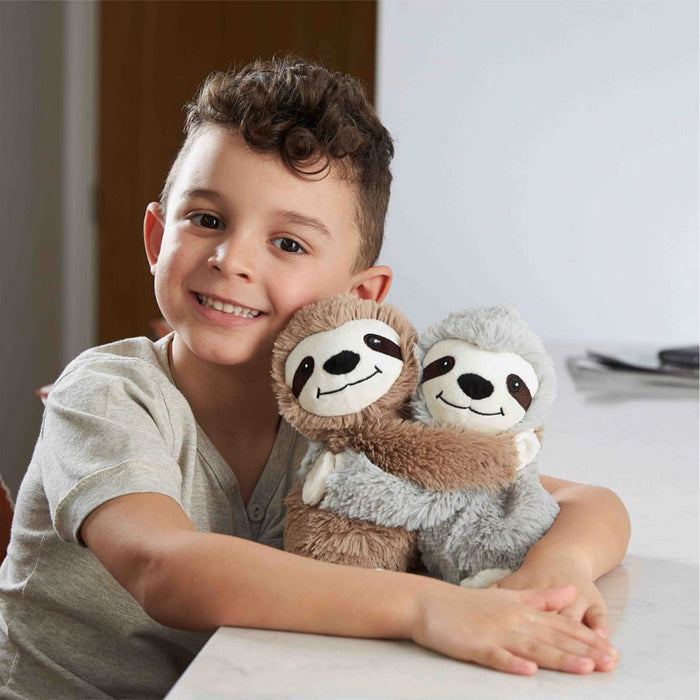 Little boy smiling and hugging Warm Weighted Lavender Scented Sloth Hugs Plush Warmies