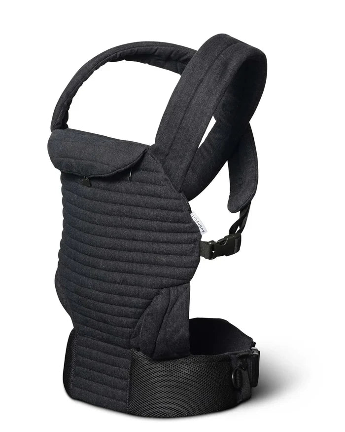 A black denim quilted baby carrier with padded shoulder straps and a breathable waist belt, shown from a three-quarter angle on a white background.