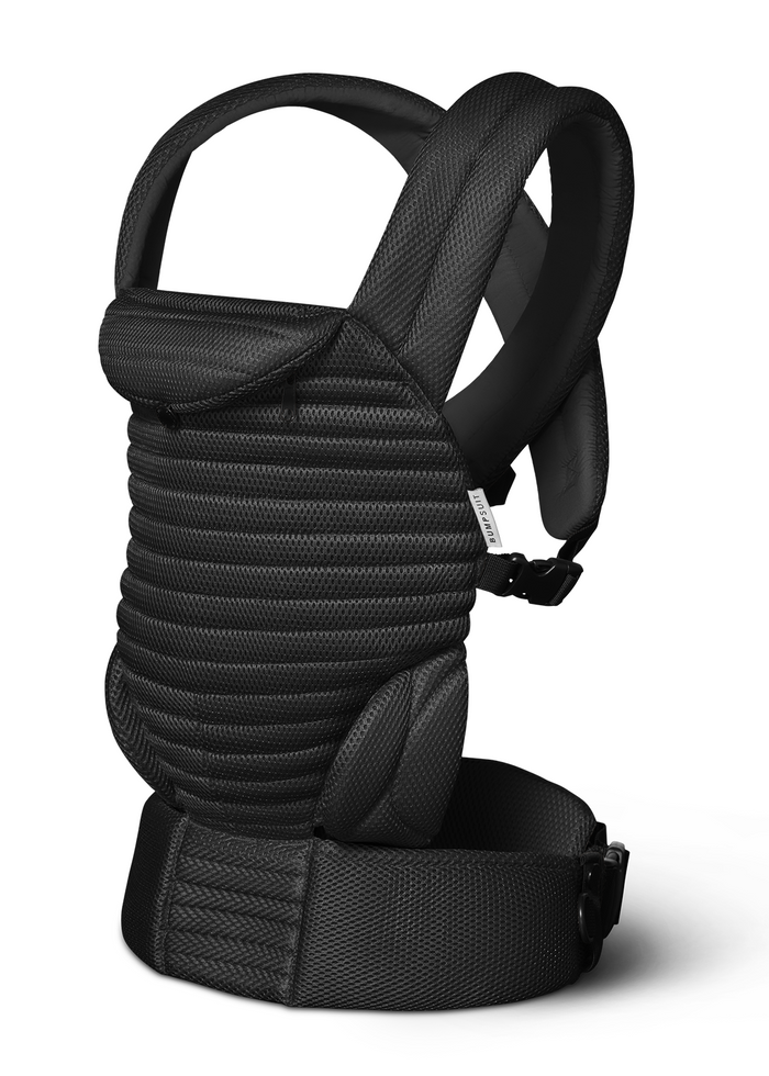 A side view of the Bumpsuit black mesh baby carrier with padded adjustable shoulder straps,  adjustable waist belt, shown on a clean white background.