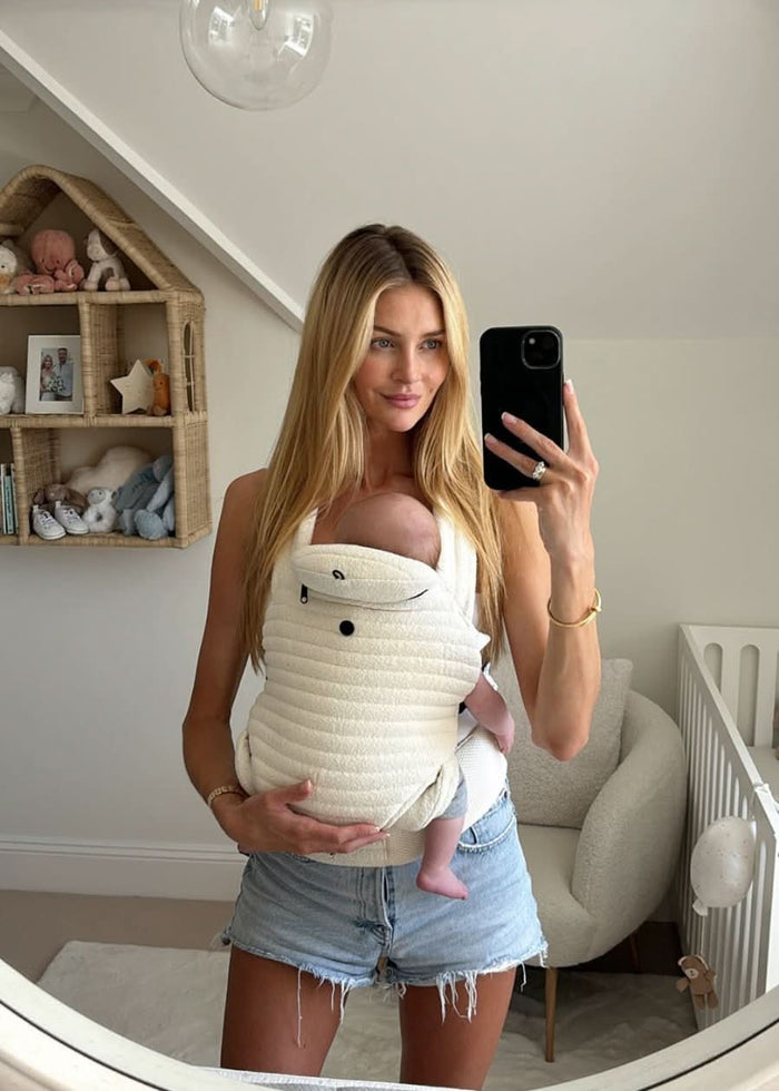 Georgia trehane in the ivory coloured armadillo baby carrier in a babies bedroom