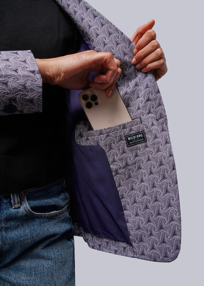 S=Person holding a phone in a patterned jacket interior pocket with a visible brand label.