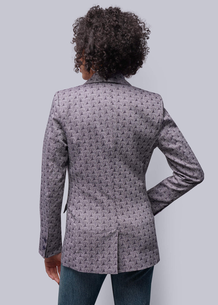 S=Person wearing a patterned gray blazer on a light gray background