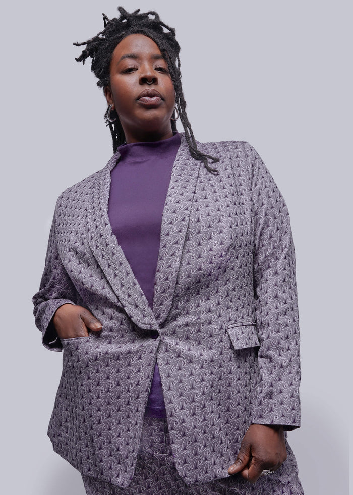1X=Person wearing a purple textured blazer over a purple top on a plain background