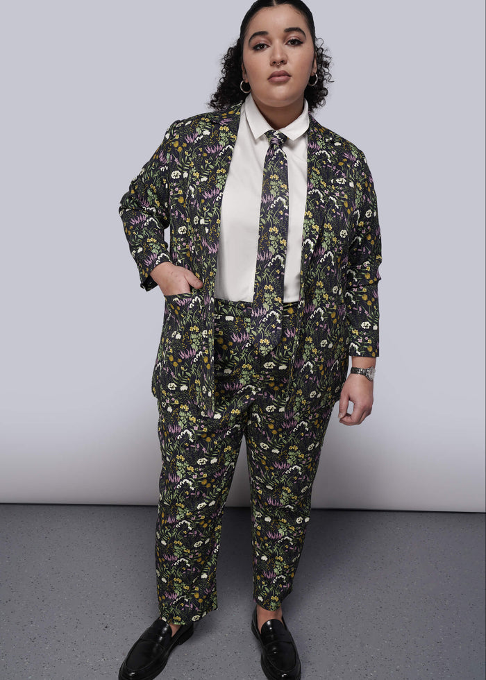 1X=Person wearing a floral suit and tie with a plain background
