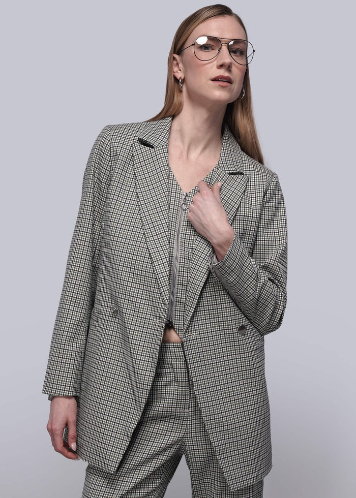 S=Person wearing matching plaid vest, blazer, and trouser against plain background.