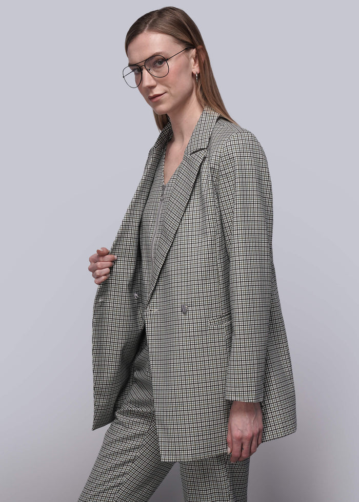 S=Person wearing a plaid suit against a plain background