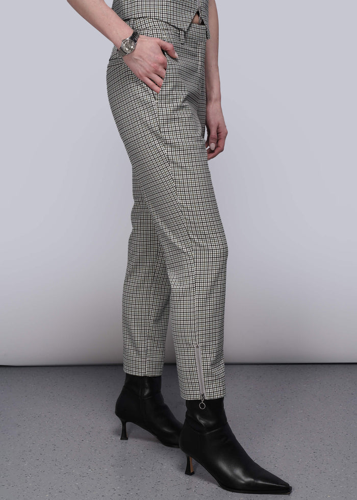 S=Side view. of person wearing plaid pants and black ankle boots on a plain background