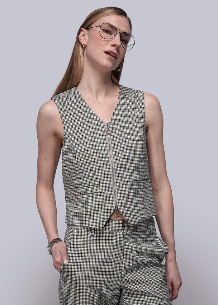 S=Person wearing a checkered vest and pants against a plain background