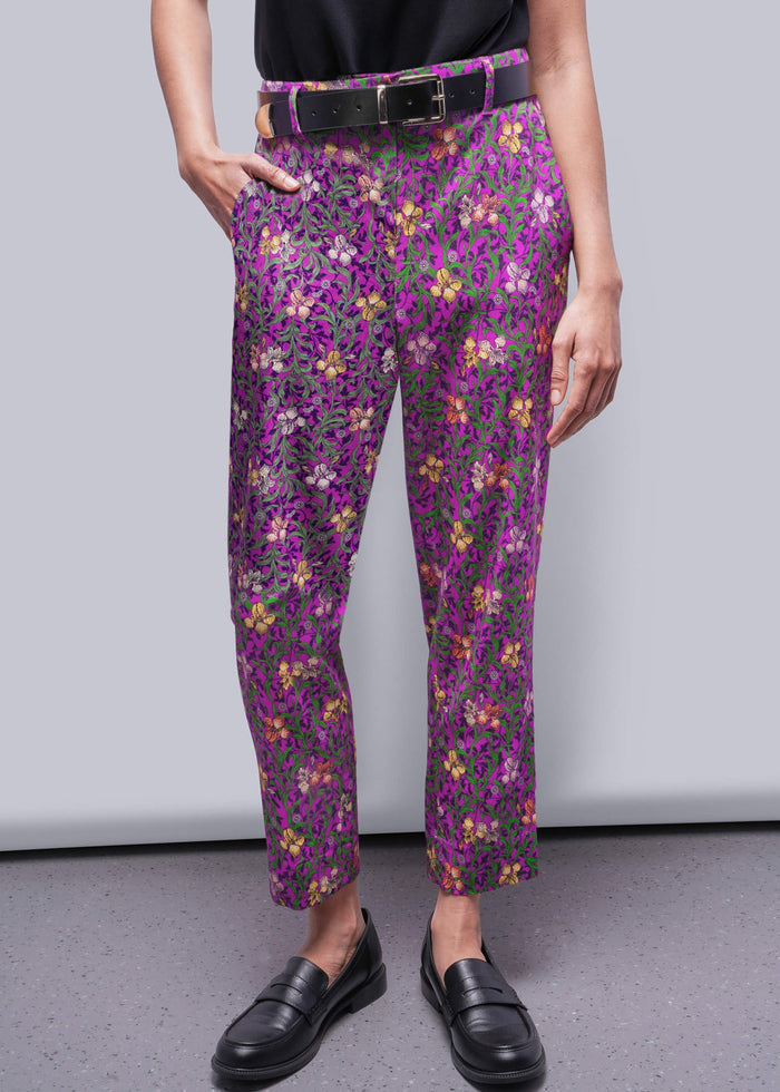 S=Person wearing purple floral pants with a plain background