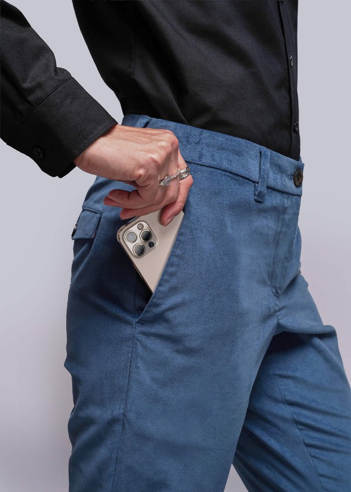 S=Person wearing blue pants with a phone in the pocket against a white background