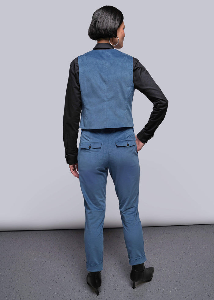 S=Person wearing a blue vest and pants with black sleeves against a plain background