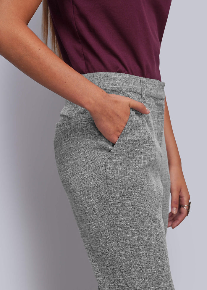 S=A close-up of a person wearing gray textured trousers with a side pocket, paired with a dark burgundy top, against a plain light gray background.