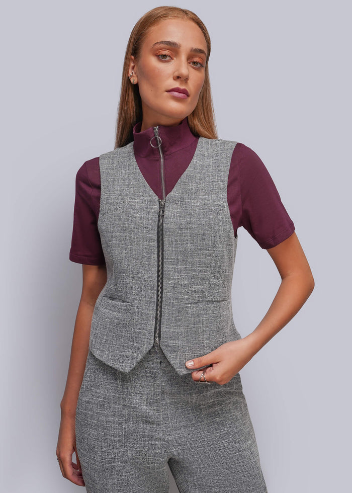 S=A woman modeling a gray zip-front vest over a short-sleeve burgundy top, paired with matching gray trousers, against a light gray studio background.