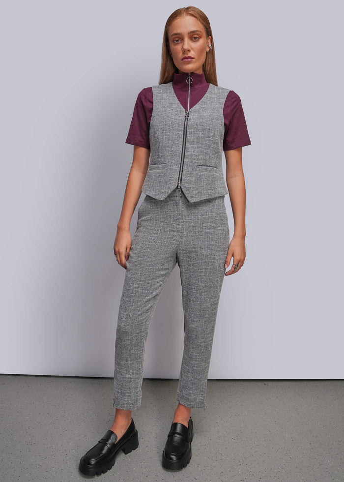 S=A model stands against a light gray studio wall wearing a coordinated gray vest and trouser set over a burgundy short-sleeve mock-neck top, paired with black loafers.