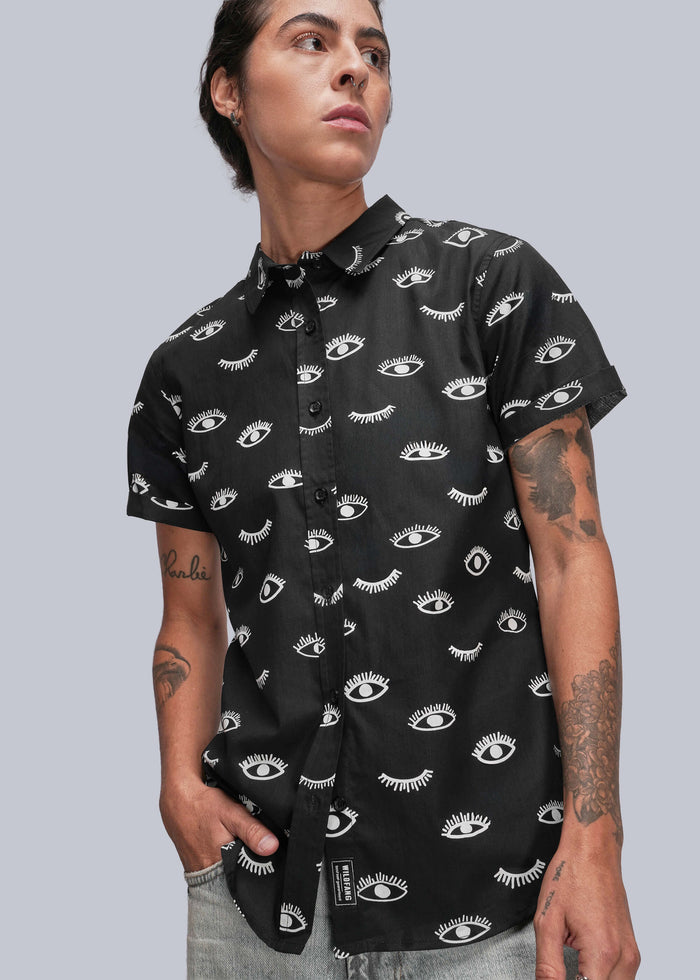 S=Person wearing a black short-sleeve shirt with white pattern against a gray background