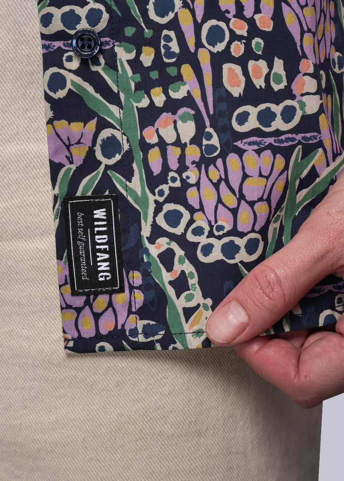S=Patterned fabric with a visible brand label held by a hand on a neutral background