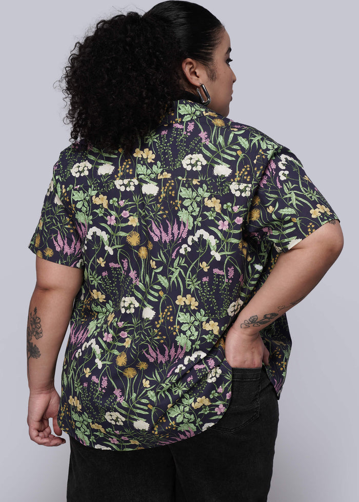 1X=Back of person wearing a floral patterned shirt against a plain background