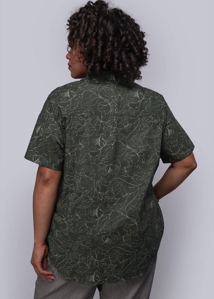 1X=Person wearing a green patterned shirt against a white background
