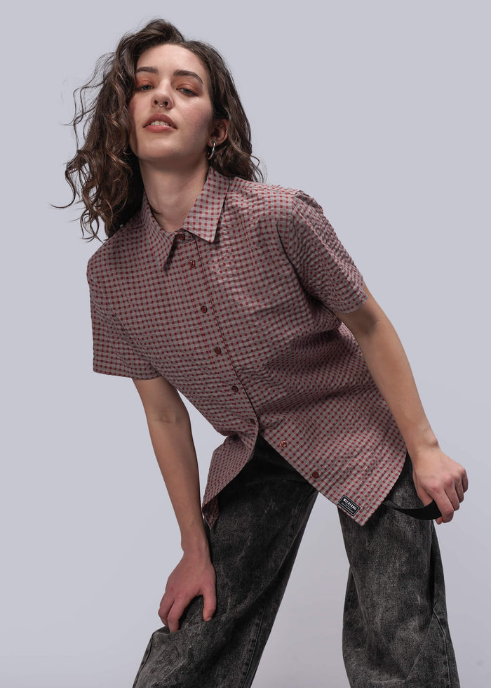 S=Person wearing a checkered shirt and wide-leg pants against a plain background
